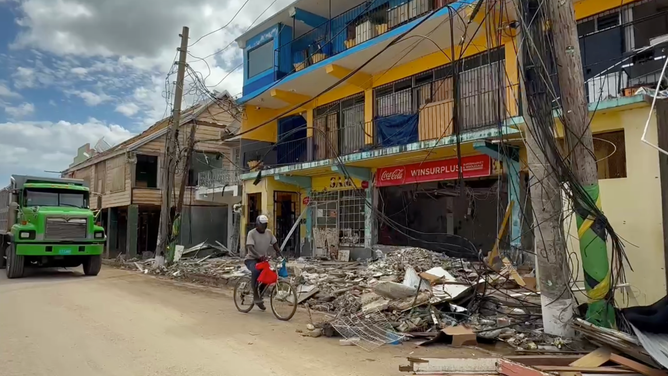 Piles of debris lie around Black River, Jamaica on Nov. 11, two weeks after Hurricane Melissa made landfall.